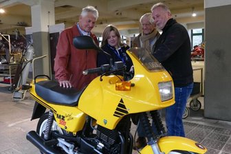 Der ehemalige Schlosser Fred Meyer, Museumsmitarbeiterin Dajana Kunze, der frühere Konstruktionsleiter Franz Wolf sowie der letzte Leiter der Versuchsabteilung bei MZ, Bernd Baumgartl (von links) schauen sich eine MZ mit Rotax-Motor genauer an.