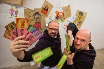 Wie zu Intershop-Zeiten in der DDR: Plauener Künstler bringen Forumschecks in Umlauf - Jörg Piesendel alias Alfred Mogelseng (links) eröffnet am Freitag in der Plauener Galerie Forum K seine neue Ausstellung. Er und Markus Schneider halten die neuen Forumschecks in den Händen. 