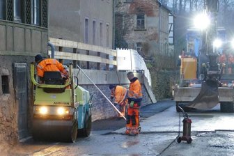 Wieder freie Fahrt durch Borstendorf - Die Arbeiten an der August-Bebel-Straße in Borstendorf befinden sich in den letzten Zügen. Hier versehen Arbeiter den Straßenrand mit Asphalt.
