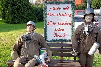 Wieder mit Helm und Gasmaske: Beklaute Feuerwehrpuppen in Rechenberg-Bienenmühle neu ausgestattet - Kurz vor dem Heimatfest hatten unbekannte den beiden Feuerwehrpuppen Helm und Gasmaske gestohlen. Beides ist inzwischen ersetzt.