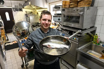 Wiedereröffnung der „Wasserschänke“: Krumbach freut sich auf neue kulinarische Erlebnisse - Koch Tobias Kühnel bereitet im Tiegel eine Forelle vor. Wie der bisherige Besitzer setzt das Team auf Fischgerichte aus einheimischen Flüssen: Forelle „Müllerin Art“, Gebackene Bärlauch-Forelle und Geräucherte Forelle für je 19,80 Euro, zudem Matjes für 16,20 Euro und Lachsfilet für 19,80 Euro.