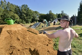 Wieso beim Mountainbike-Spektakel auf der „Dirt Wies“ in Marienau der Blick zur Windprognose geht - Mit Schaufel und Gießkanne legten die Helfer wie Eric Winkler in den vergangenen Tagen letzte Hand an die Strecken auf der „Dirt Wies“ in Marienau.