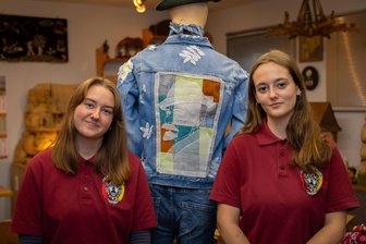 Wieso Klöppelkunst aus dem Erzgebirge zwei Völker einander nahebringt - Hermine Mokry (r.) und Marlen Melzer mit der Jacke mit dem geklöppelten Anton Günther.