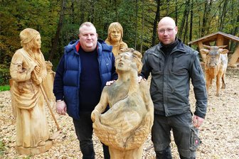 „Wilisch-Beach“: Neuer Gelenauer Rastplatz bereichert Radwanderweg zwischen Oberwiesenthal und Leipzig - Gelenaus Bürgermeister Knut Schreiter (links) und Kettensäge-Künstler Tino Schubert inmitten der Siedlerfamilie, die auf dem neuen Rastplatz an der Wilisch zu bestaunen ist.