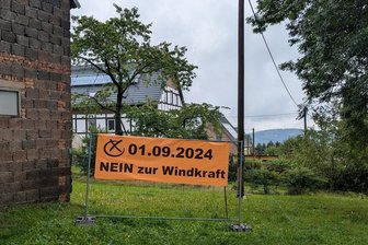 Windkraftanlagen: In Stadt im Erzgebirge erfolgt Bürgerbefragung parallel zur Landtagswahl - Schon seit Langem hängen überall im Elterleiner Ortsteil Hermannsdorf Plakate gegen Windkraftanlagen. Dieses Banner von Windkraftgegnern weist auf die bevorstehende Bürgerbefragung hin.