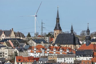 Windrad-Projekte zwischen Meerane und Waldenburg: Stadtwerke legen Pläne auf Eis - Gemeinderat verfasst Protestbrief - Aus Richtung Waldenburg sofort zu sehen: Neben Rathaus, Kirche und Eurogymnasium dreht sich das Windrad im Oberwieraer Ortsteil Harthau.