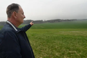 Windräder spalten Vogtlanddorf – Bürgermeister: „Die meisten Eigentümer sind dagegen“ - Neustadts Bürgermeister Bert Blechschmidt zeigt auf das Waldgebiet, wo die Windkrafträder stehen sollen.
