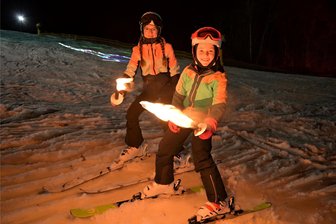 Wintersport im Erzgebirge: Am „Gletscher“ in Eibenstock geht noch was - Haben das Wochenende noch einmal für eine Fackelabfahrt am „Gletscher“ in Eibenstock genutzt: Judith (vorn) und Luisa Zechel. Wetterbedingt ruht nun erst einmal der Skibetrieb am Adlerfelsen.