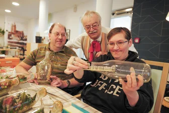 Winzige Welten, große Wirkung: Warum in einem Plauener Pflegeheim Miniaturen entstehen - Hubert Gehlert (Mitte) zeigt wie’s geht: Die Aspida-Bewohner Katrin Fennert und Holger Fuchs sind geduldige Schüler.