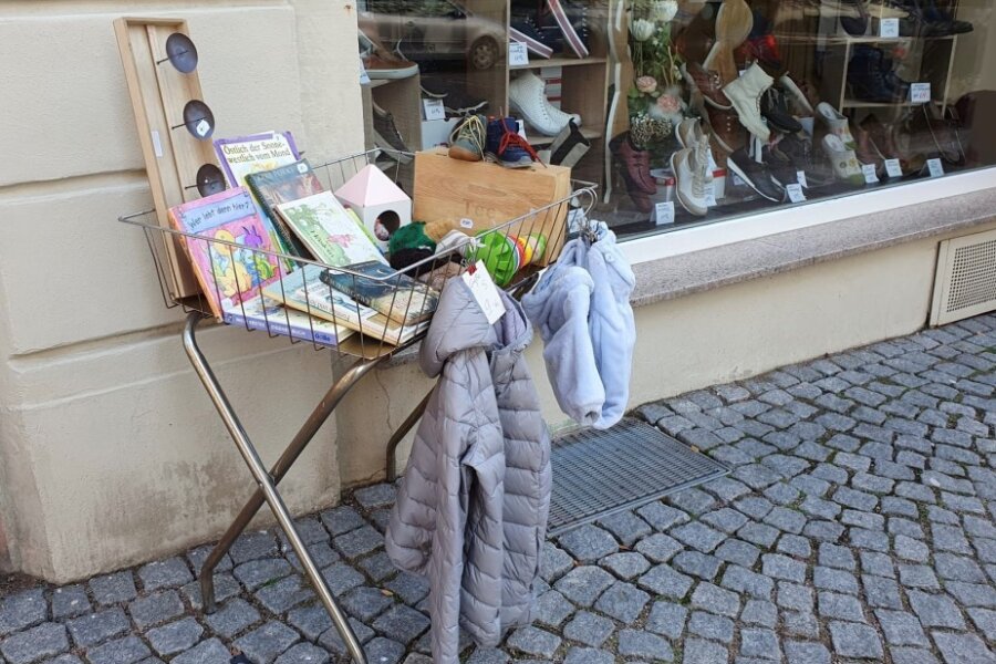 Vor dem Schuhgeschäft an der Rochlitzer Straße in Mittweida hat die ehemalige Inhaberin Ilona Krebs einen kleinen Stand mit gebrauchten Dingen für Kinder aufgebaut.