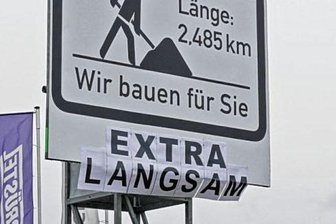 "Wir bauen extra langsam": Schilderstreich an der B 180 in Hohenstein-Ernstthal - Die Bautafel an der B 180 hat eine Ergänzung von frustrierten Scherzbolden erhalten.