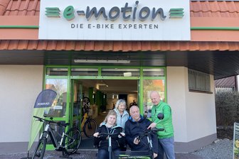„Wir haben den ersten Berg bezwungen“: Wie ein E-Dreirad Chantals Leben mit einem Geburtsdefekt verändert - Chantal Julia und ihre Pflegeeltern Harald und Gitta Ebert vor dem Geschäft E-Bike-Welt Chemnitz mit Chef Matthias Kleinke (rechts).