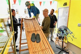 "Wirbelsturm" für Halsbrücke: Kinderfreundlicher Ort um Hort reicher - Über eine Rutsche erreichten die Grundschüler ihren neuen Hort "Wirbelsturm" an der Grundschule Halsbrücke. Die Erzieher Ingo Uhlemann, Manfred Homann und Moritz Müller (v. l.) gaben Hilfestellung am ungewöhnlichen Eingang.