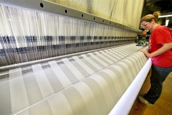 Wirtschaft auf Talfahrt: Droht dem Erzgebirge eine Insolvenz-Welle? - Eine Mitarbeiterin überwacht einen Webstuhl mit Damast in der Weberei Curt. Das Traditionsunternehmen in Aue musste Ende April einen Antrag auf ein Insolvenzverfahren stellen.