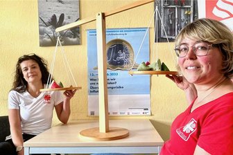 Wo den Rotstift ansetzen? Inflation schmälert auch im Erzgebirge immer mehr Geldbeutel - Susann Räder (l.) und Kristina Möglich von der Caritas in Aue nutzen bei der Schuldnerberatung auch diese originelle Waage. Sie zeigt, wie viel Geld Dinge wie Energydrink, Zigaretten, Lippenstift und Kaugummi kosten.