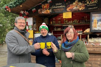 Wo der Glühwein auf dem Auerbacher Weihnachtsmarkt sogar billiger wurde - Die „Freie Presse“-Redakteure Gunter Niehus (li.) und Cornelia Henze testen den Glühwein von Paolo Iera (Mitte).
