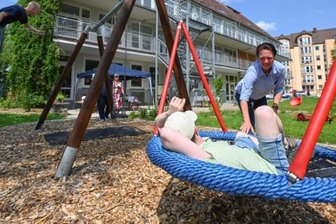 Wo ein Außenbereich zu einer grünen Ruheoase wird - Das Autismuszentrum hat seinen Garten mit Spielgeräten und vielen Pflanzungen umgestaltet und verschönert. Mitarbeiterin Nicole Wyrzykoski schiebt eine Schaukel an, die aufgearbeitet wurde. 