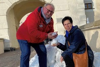Wo in Freiberg Schnee liegt - Petra Fiedler und Frank-Peter Barth freuen sich über den kleinen Schneeberg vorm Schloss Freudenstein in Freiberg.