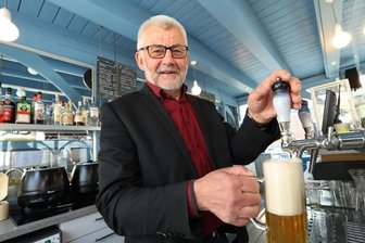 Wo Maibäume und Freibier auf die radelnden Gäste warten - Bürgermeister Bernd Pohlers beim Test an der Zapfanlage. 