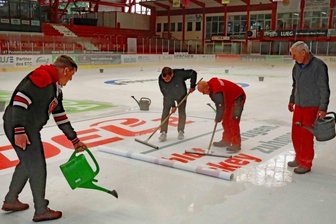 Wo mitten im Sommer die Eiszeit beginnt - Daniel Katzke und Stefan Steinbock von den Eispiraten sowie die beiden Eismeister Jens Scholz und Stefan Wolf (von links) haben am Mittwoch die Werbung auf die Eisfläche aufgebracht - erstmals wurden hierfür Folien eingesetzt.