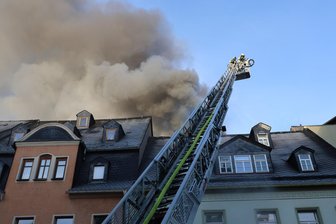 Wohnungsbrand im Erzgebirge: Flammen greifen auch auf zweites Wohnhaus über - Dicke, dunkle Rauchschwaden ziehen am Montagmorgen über den Markt in Schwarzenberg. Dort brennt eine Dachgeschosswohnung.