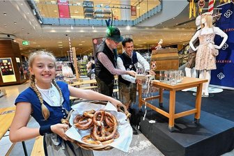 Wooosn Chemnitz: Die Zeit von Dirndl, Lederhosen und Brezeln naht - Die elfjährige Jona Bonesky hält den Brezel-Korb, während Vater Henrik Bonesky und Kaufhofchef Torsten Dunkelmann (mit Hut) ein Faß Bier anstechen. Bei der echten „Wooosn“ im September soll dann nichts daneben gehen.