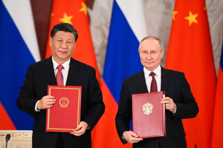 Xi Jinping beendet Staatsbesuch in Moskau - Chinas Präsident Xi Jinping und sein russischer Amtskollege Wladimir Putin zeigen während einer Unterzeichnungszeremonie Mappen mit den neuen Abkommen.