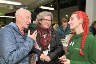 XL-Kochshow in Zwickau begeistert, aber das Essen in der Halle nicht - Jürgen Geigner und Elke Geigner im Gespräch mit Denise Eichler, Trainerin Digitalakademie AOK PLUS (re.).
