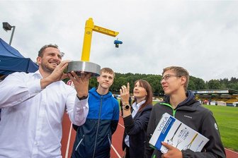 XXL-Azubimesse in Plauen: So wirbt Vogtlands Wirtschaft um Nachwuchs - Max Wunderlich (links) und Sandra Zöphel von der Firma Lash + Lift aus Oelsnitz zeigen Silas Gemeinhardt und Luca Rosenbaum (rechts) aus Muldenhammer, wie Zurr- und Hebetechnik funktioniert. 