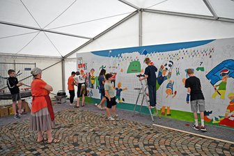 XXL-Malprojekt in Oederan: Fußballerstadion entsteht im „Alle-Welt-Zelt“ - Im „Alle-Welt-Zelt“ Oederan wird eine Fankurven-Szene gestaltet.