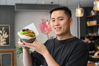 „Yumi Kitchen“ in Chemnitz: Mit koreanischen Burgern zu Star-Koch Tim Raue? - Manh Bao Nguyen mit einem Burger, wie er im „Yumi Kitchen“ serviert wird.