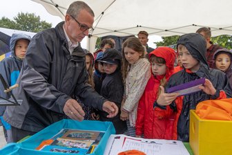 Zehn Millionen Euro für neues Schulgebäude im Erzgebirge - Trägervereinsgeschäftsführer Steffen Simon sammelt mit den Grundschülern die Gegenstände, die zur Grundsteinlegung des Neubaus in Annaberg-Buchholz mit in die Zeitkapsel wandern.