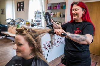 „Zeitweise habe ich eine unglaubliche Wut“: Friseurin aus dem Erzgebirge soll komplette Coronahilfe zurückzahlen - Fürs Foto lächelt Mandy Herrmann (r.), auch wenn es schwerfällt. Mit im Bild: Kundin Jennifer Brandt.