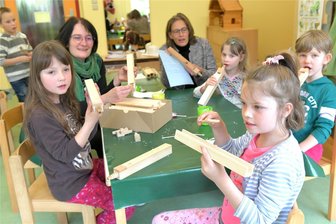 Zethau: Junge Orgelbauer mit Eifer bei der Sache - Zu den Zethauer Orgeltagen konnten Mädchen und Jungen des Christlichen Kinderhauses „Ankerplatz“ am Donnerstag gemeinsam mit Juliane Schwarz-Bierschenk (hinten) von der Gottfried-Silbermann-Gesellschaft Freiberg Orgelpfeifen basteln. Sie leimten vorgefertigte Einzelteile aus Holz zusammen. Auch Kitaleiterin Andrea Schmieder hatte viel Spaß dabei.