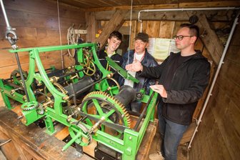 Zöblitzer Kirchturmuhr nach vier Jahren Stillstand wieder angeschoben - Noah Kießling, Thomas Schwarz und Tobias Haueis (v. l.) werfen einen Blick auf die sanierte Turmuhr der Stadtkirche Zöblitz.