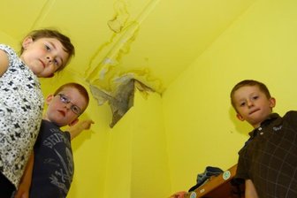Zschopauer Kita "Spatzennest" von Unwetter doppelt getroffen - In fast allen Räumen der Kindertagesstätte hat das undichte Dach Spuren hinterlassen. John (Mitte), Melissa und Pascal stehen in der Garderobe, wo es ebenfalls hereingeregnet hat.