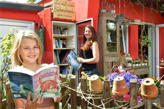 Zug: Blumenhändlerin verwandelt Kühlschrank in Bücherschrank - Am Blumenladen in Zug zeigen Inhaberin Kathleen Wunderlich und ihre Tochter Frida (11) den Bücherschrank.