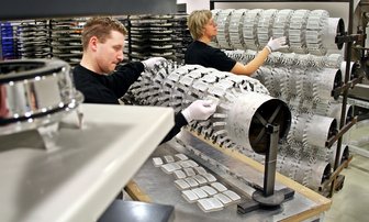 Zulieferer will in einstiger Schule expandieren - 
              <p class="artikelinhalt">Maik Hupfer (l.) und Rommi von Ryssel bestücken Geräteträger mit Teilen vor der Oberflächenveredlung. Die Teile werden - so wie links im Vordergrund ein fertiges Stück - im Vakuum beschichtet, in dem eine völlig saubere Atmosphäre herrscht.</p>
            