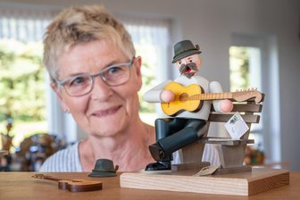 Zum 150. Geburtstag von Anton Günther: Seiffenerin widmet Heimatdichter besonderes Räuchermännchen - Der Anton Günther von Eva Beyer sitzt zufrieden auf einer Gartenbank und musiziert.