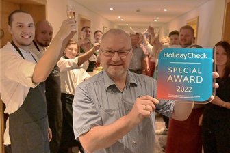 Zum dritten Mal durch "Holiday Check" ausgezeichnet: Köhlerhütte Fürstenbrunn bleibt Sachsens bestes Hotel - Heiko Schmidt, Inhaber der Köhlerhütte, hält voller Stolz den Preis hoch und findet herzliche Worte für jeden einzelnen seiner Mannschaft. Denn nur als Team können sie den Gästen eine so konstante Leistung bieten.