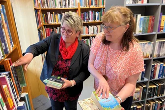 Zum zehnten Mal: Bibliothek im Erzgebirge zieht erneut um - Bürgermeisterin Elke Schmieder und Bibliotheksmitarbeiterin Michaela Löschner sortieren Bücher ein.