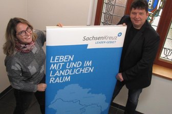 Zuschüsse: Künftige Bauherren sollen mitbestimmen - Harthas Wirtschaftsförderin Nicole Salzbrenner und Bürgermeister Ronald Kunze weisen mit einem Aufsteller schon mal auf den baldigen Start einer neuen Förderperiode hin. 