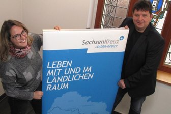 Zuschüsse: Künftige Bauherren sollen mitbestimmen - Harthas Wirtschaftsförderin Nicole Salzbrenner und Bürgermeister Ronald Kunze weisen mit einem Aufsteller schon mal auf den baldigen Start einer neuen Förderperiode hin.