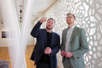 Zwei Jahre Fabrik der Fäden in Plauen: So fällt die Bilanz des Spitzenmuseums aus – und welches neue Format jetzt geplant ist - Sebastian Dressel (links) ist Chef der Plauener Museen. Er erklärt Bürgermeister Tobias Kämpf, wie jeder einzelne Faden der Deko-Wand regelmäßig nachgespannt werden muss.