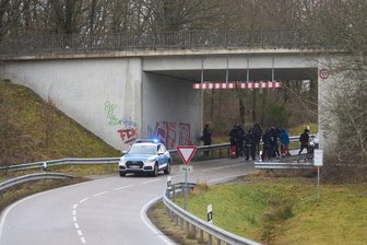 Polizisten sammeln sich an einer Unterführung.