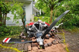 Zwei Tote bei Absturz eines Kleinflugzeuges in Wohngebiet - Ein Propeller der Maschine liegt vor einem Wohnhaus.