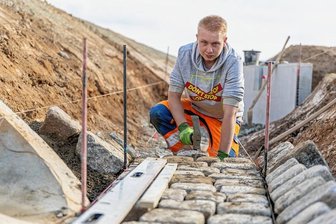 Zwei vogtländische Baufirmen für Top-Berufsausbildung geehrt - Kevin Müller aus Kleingera, der beim Hoch- und Tiefbau Reichenbach im 2. Lehrjahr den Beruf Straßenbauer erlernt, bei Pflasterarbeiten auf der Baustelle in Christgrün. Etwas mit Handwerk war sein Berufswunsch. 