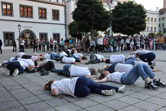 Zwei Welten auf dem Zwickauer Hauptmarkt: Ukrainer hier, Putin-Versteher dort - Die Tänzerinnen und Tänzer aus der Ukraine liegen auf dem Boden. Sinnbild für das Leid in ihrem Land.