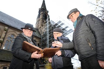 Zwickau-Planitz: Kaputter Sandstein – Turm der Lukaskirche wird aufwendig restauriert - Wolfgang Mielke, Ulrich Thaut und Gabriel Püschmann vom Förderverein Lukaskirche vor dem eingerüsteten Turm der Kirche in Planitz.