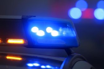 Ein Polizeiauto mit eingeschaltetem Blaulicht steht an einer Unfallstelle.